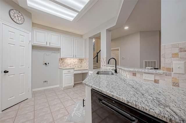 kitchen featuring white cabinetry, sink, light stone counters, and light tile patterned floors