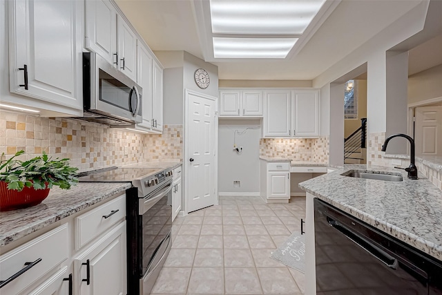 kitchen with light tile patterned floors, stainless steel appliances, sink, and white cabinets