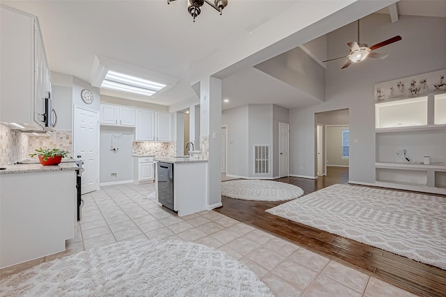 kitchen featuring light tile patterned floors, dishwasher, backsplash, vaulted ceiling with beams, and white cabinets