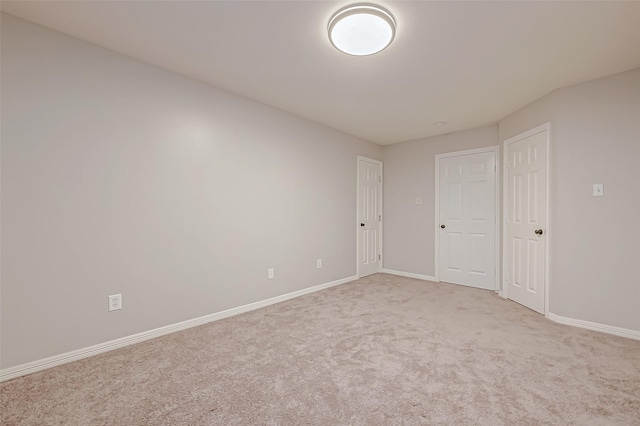 spare room featuring light colored carpet