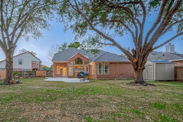 back of house with a patio, a lawn, and a shed