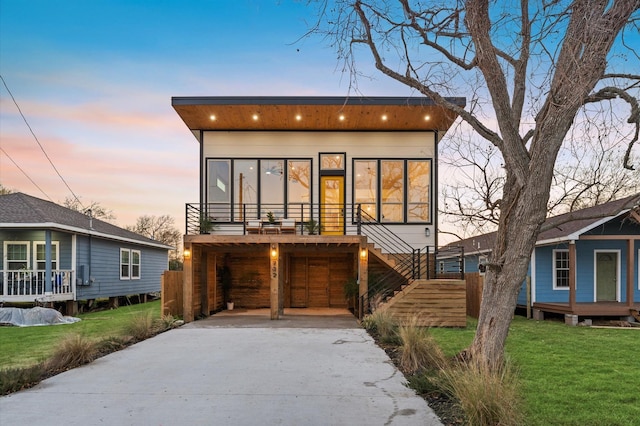 contemporary home featuring a lawn and a carport