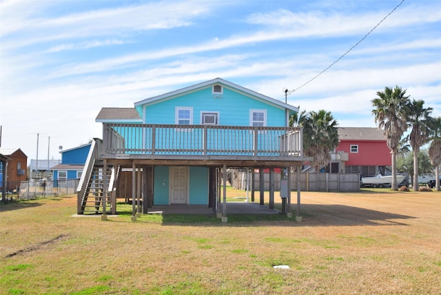 back of property featuring a deck and a lawn