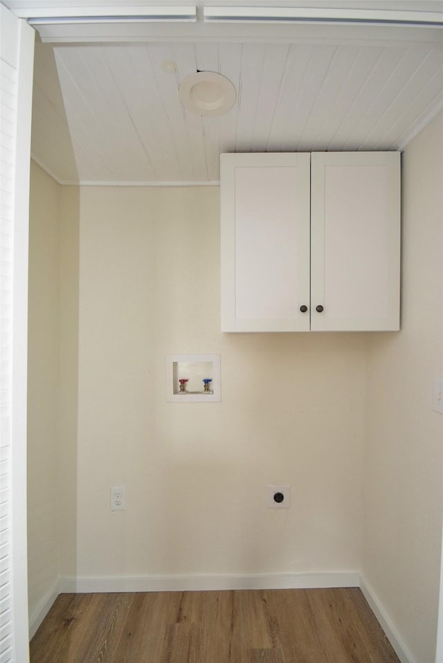 washroom featuring electric dryer hookup, hardwood / wood-style floors, hookup for a washing machine, and cabinets