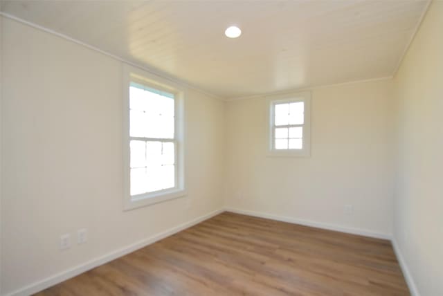 empty room featuring ornamental molding and wood-type flooring