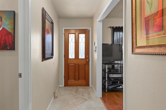 entryway featuring a textured ceiling and light tile patterned floors