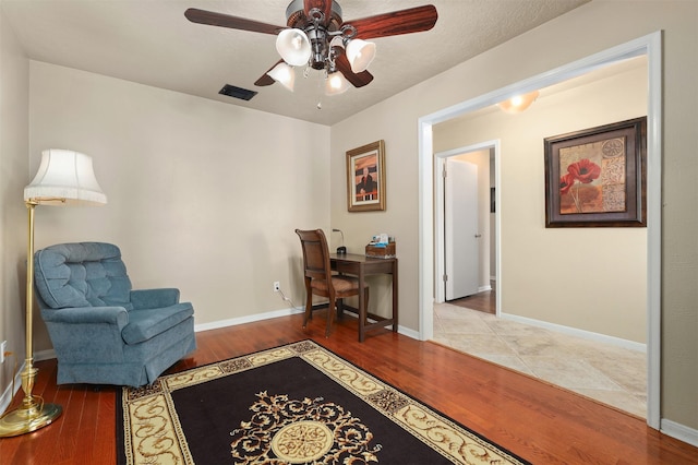 living area with hardwood / wood-style flooring and ceiling fan