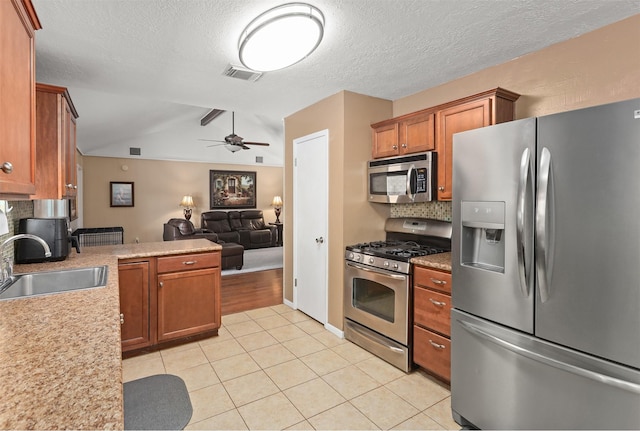 kitchen featuring sink, light tile patterned floors, ceiling fan, stainless steel appliances, and tasteful backsplash