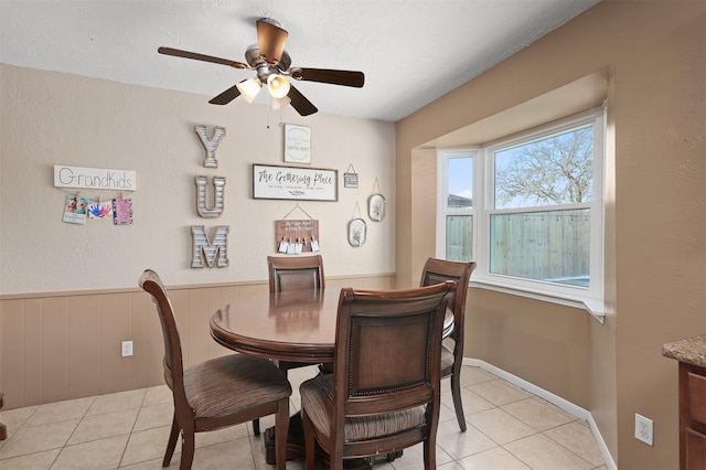 tiled dining room with ceiling fan and a textured ceiling