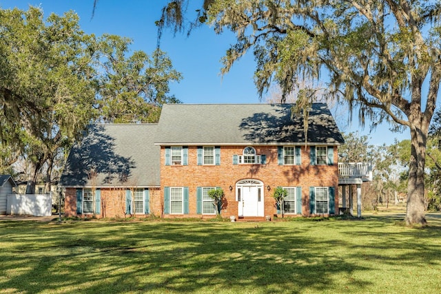 colonial-style house featuring a front yard