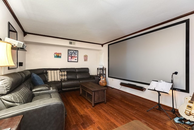 home theater with dark wood-type flooring and crown molding