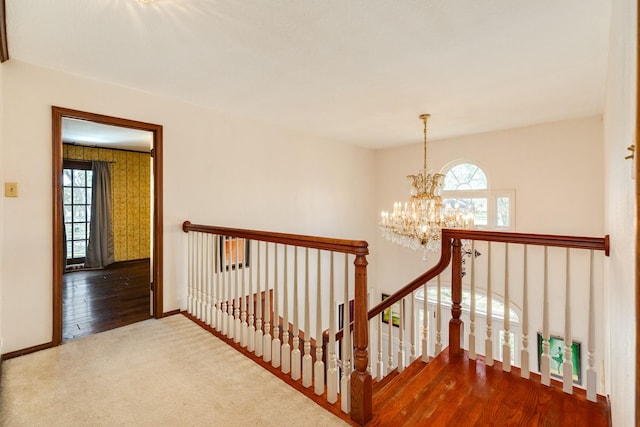 stairs with hardwood / wood-style flooring and a notable chandelier