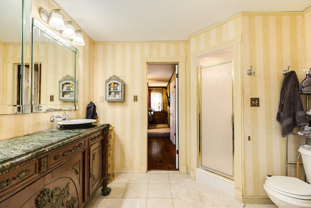 bathroom with tile patterned flooring, vanity, toilet, and walk in shower