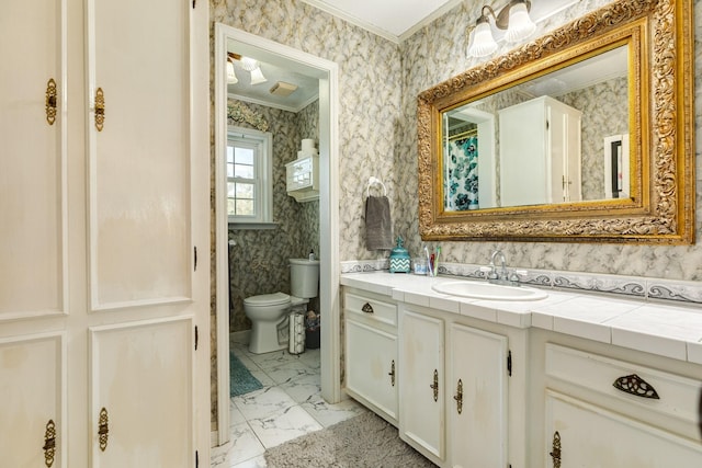 bathroom with ornamental molding, vanity, and toilet