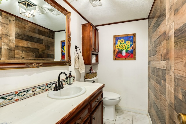 bathroom with crown molding, wooden walls, vanity, a textured ceiling, and toilet