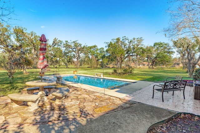 view of pool with a patio, a diving board, and a lawn