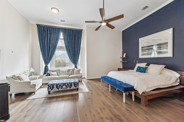 bedroom featuring ceiling fan, ornamental molding, and light hardwood / wood-style floors