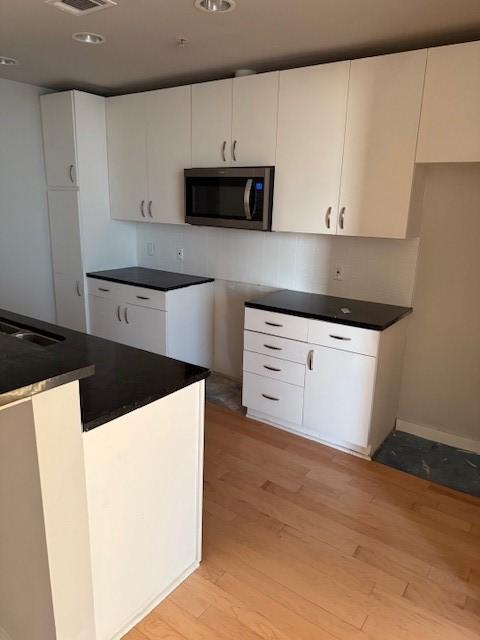 kitchen featuring white cabinetry, sink, and light wood-type flooring