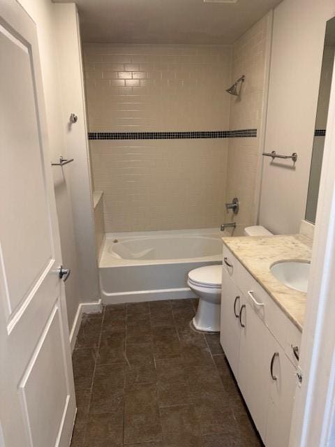 full bathroom with tiled shower / bath, vanity, and toilet