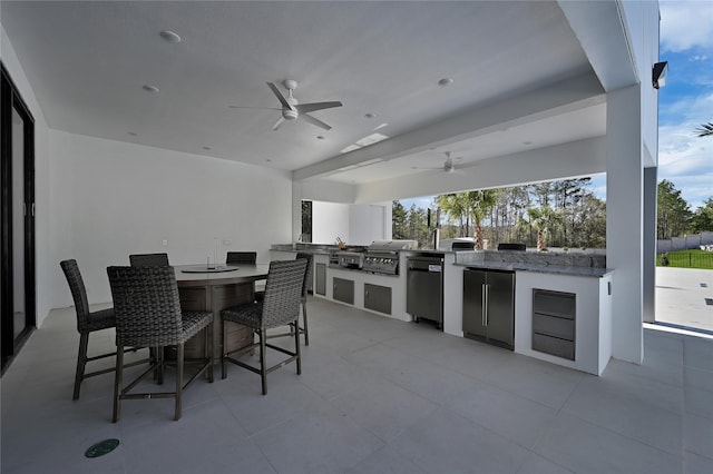 view of patio featuring ceiling fan, area for grilling, and exterior bar