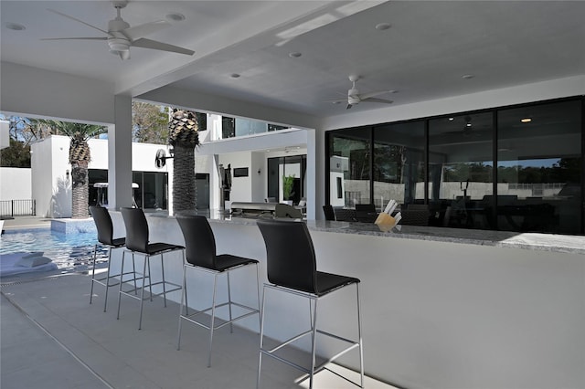 view of patio featuring a fenced in pool, an outdoor bar, and ceiling fan