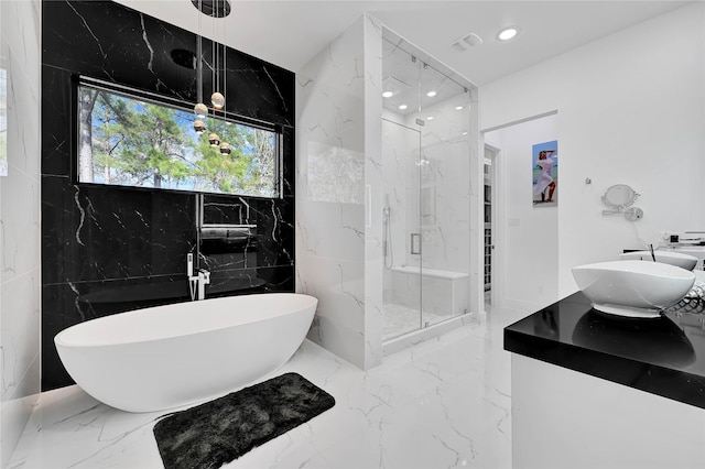 bathroom featuring independent shower and bath, sink, and tile walls