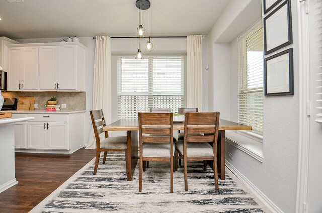 dining space with dark hardwood / wood-style flooring