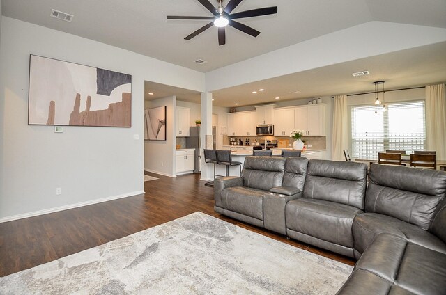 living room featuring vaulted ceiling, dark wood-type flooring, and ceiling fan