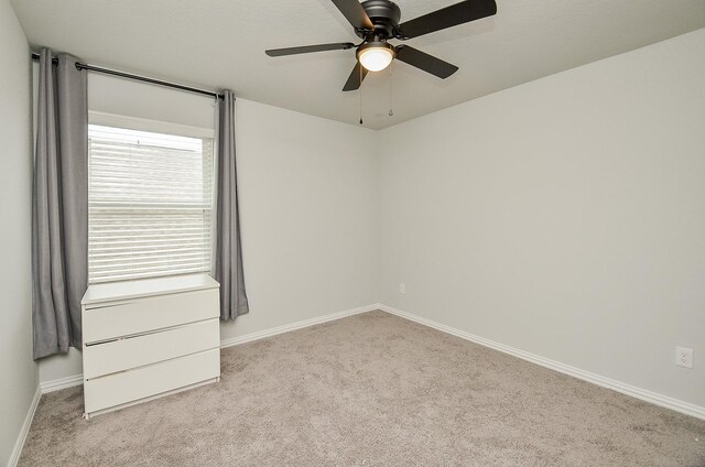 unfurnished room featuring ceiling fan and light carpet