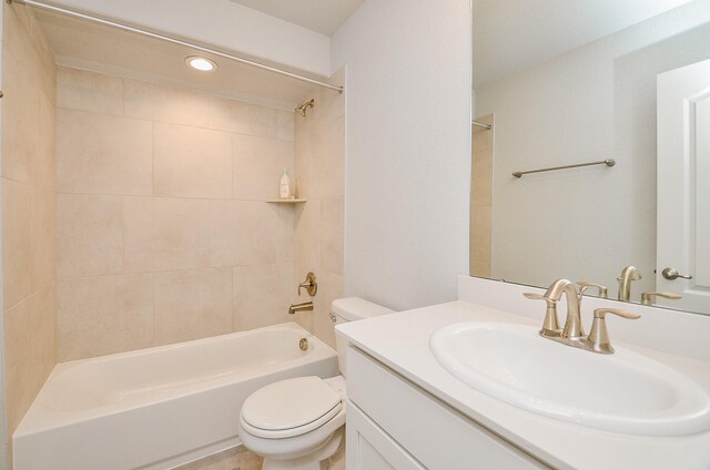 full bathroom featuring vanity, toilet, and tiled shower / bath