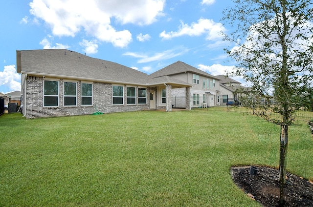 rear view of property featuring a lawn