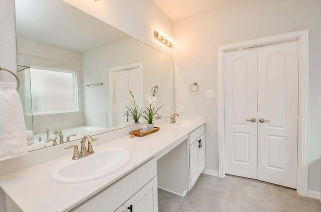 bathroom with vanity, tile patterned floors, and a tub to relax in