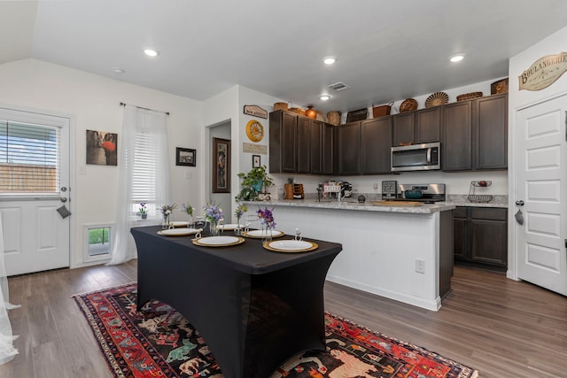 kitchen featuring hardwood / wood-style flooring, appliances with stainless steel finishes, and dark brown cabinets