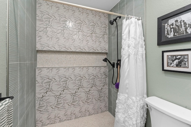 bathroom featuring curtained shower and toilet