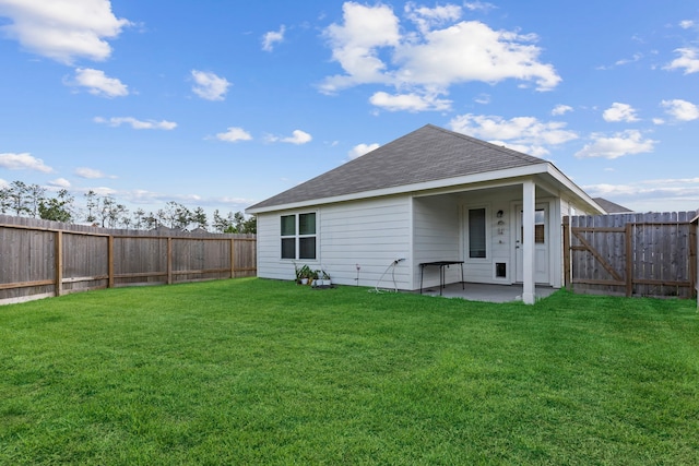 back of property with a yard and a patio