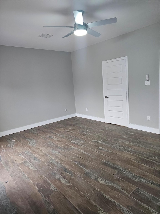 spare room with dark wood-type flooring and ceiling fan