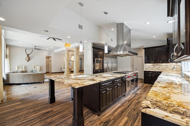 kitchen featuring sink, island range hood, a kitchen breakfast bar, a large island, and decorative backsplash