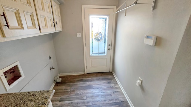 laundry room with cabinets, a healthy amount of sunlight, electric dryer hookup, and dark wood-type flooring