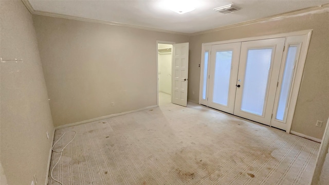 spare room featuring light carpet, crown molding, and french doors