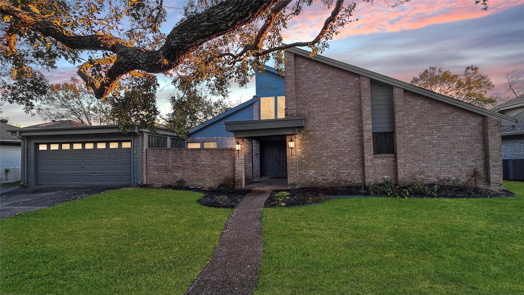 view of front of house with a garage and a yard