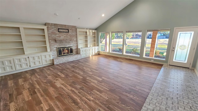 unfurnished living room with a fireplace and high vaulted ceiling