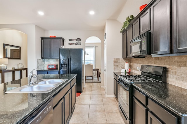 kitchen featuring tasteful backsplash, sink, light tile patterned floors, and black appliances