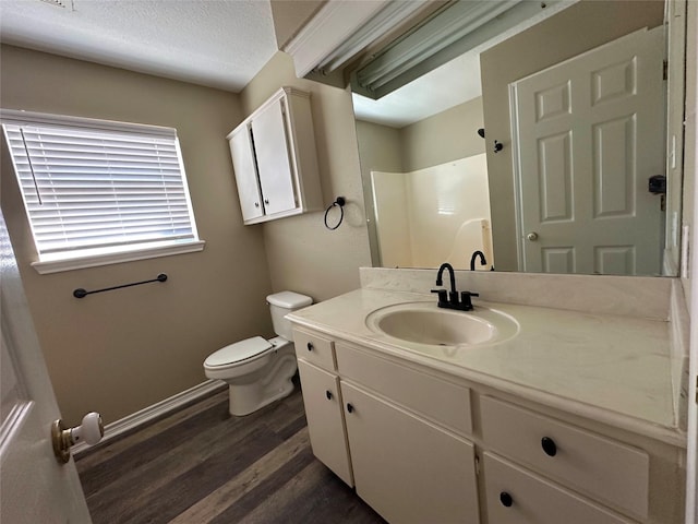 bathroom with a shower, hardwood / wood-style flooring, vanity, toilet, and a textured ceiling