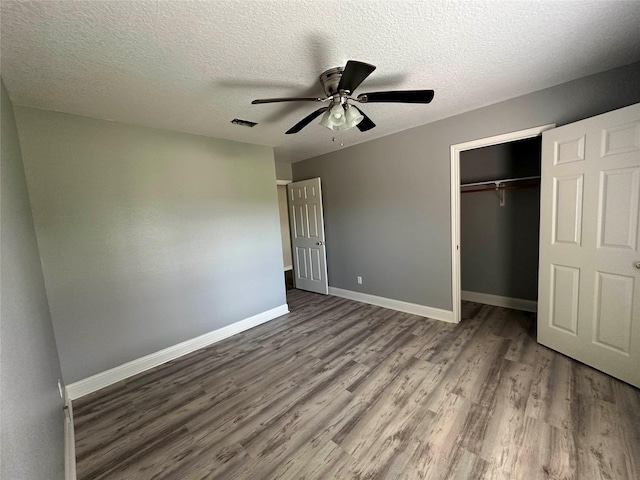 unfurnished bedroom featuring a textured ceiling, a closet, ceiling fan, and hardwood / wood-style flooring