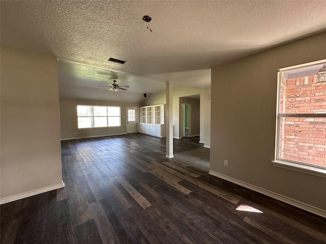 unfurnished living room featuring ceiling fan, dark hardwood / wood-style floors, and a textured ceiling