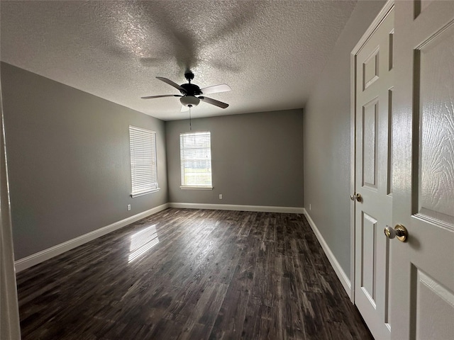 empty room featuring a textured ceiling, dark hardwood / wood-style floors, and ceiling fan