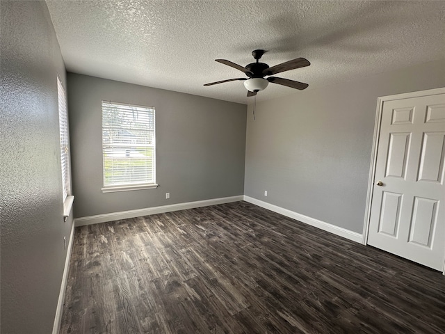 spare room featuring ceiling fan, dark hardwood / wood-style floors, and a textured ceiling