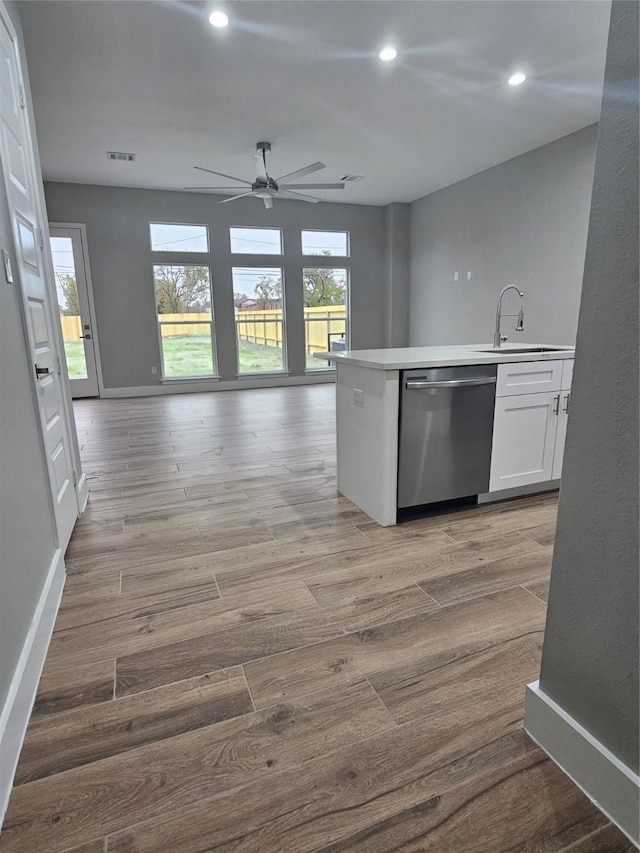 kitchen featuring sink, stainless steel dishwasher, ceiling fan, light hardwood / wood-style floors, and white cabinets