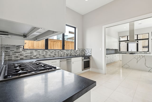 kitchen featuring tasteful backsplash, appliances with stainless steel finishes, sink, and white cabinets