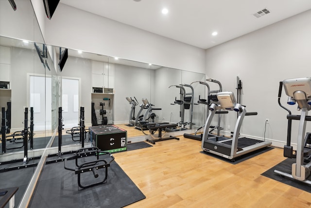 exercise room with hardwood / wood-style floors